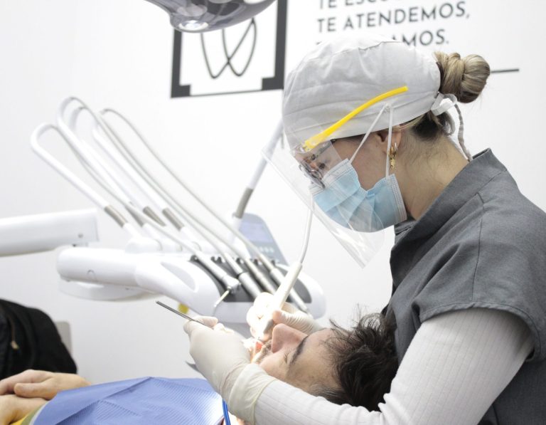 Dentista atendiendo a un paciente en un consultorio dental.