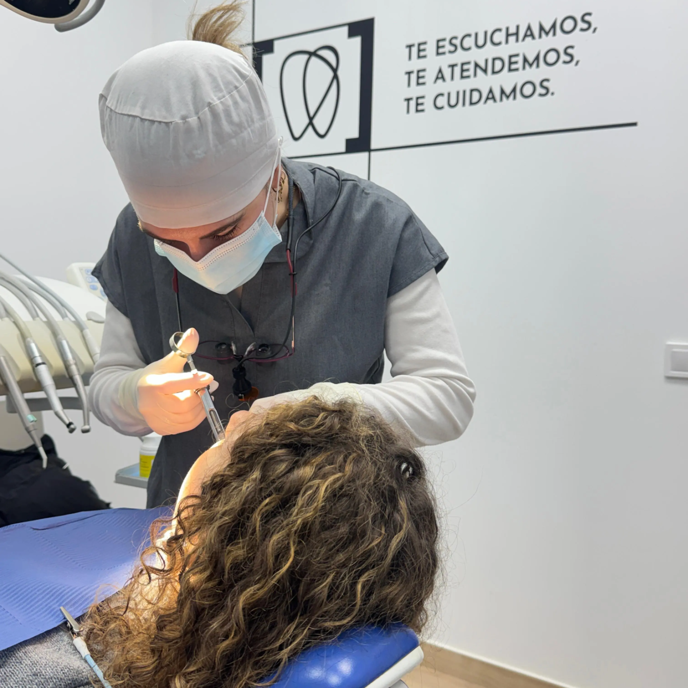 Dentista atendiendo a una paciente en un consultorio dental. 