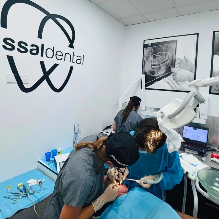 Dentista atendiendo a un paciente en un consultorio dental moderno.